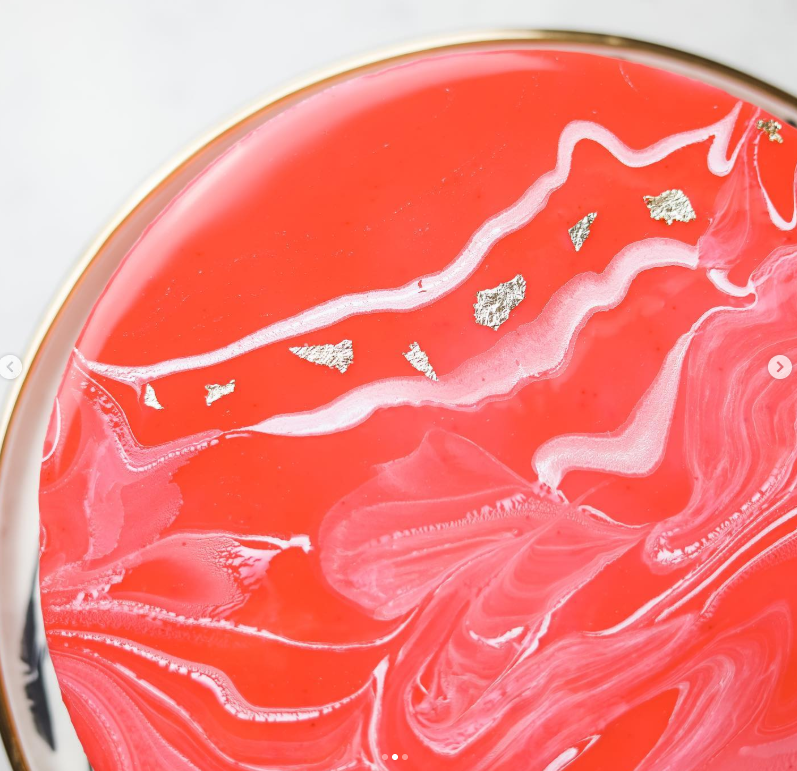 Close detail of hand-marbled mirror glaze with edible silver leaf